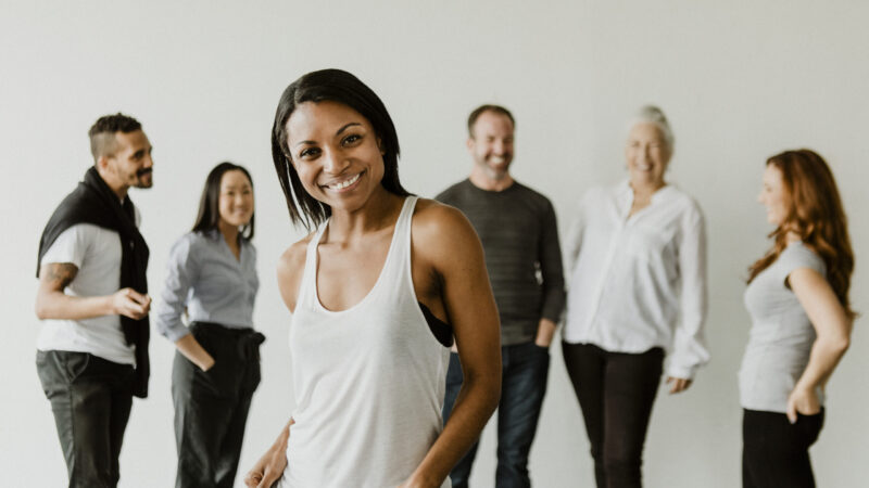 Confident black woman standing in front of her team