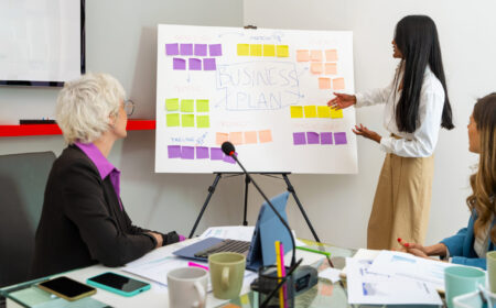 Confident African entrepreneur - Presenting strategic business plan - Engaging stakeholders with visual aids - Diverse corporate strategy meeting