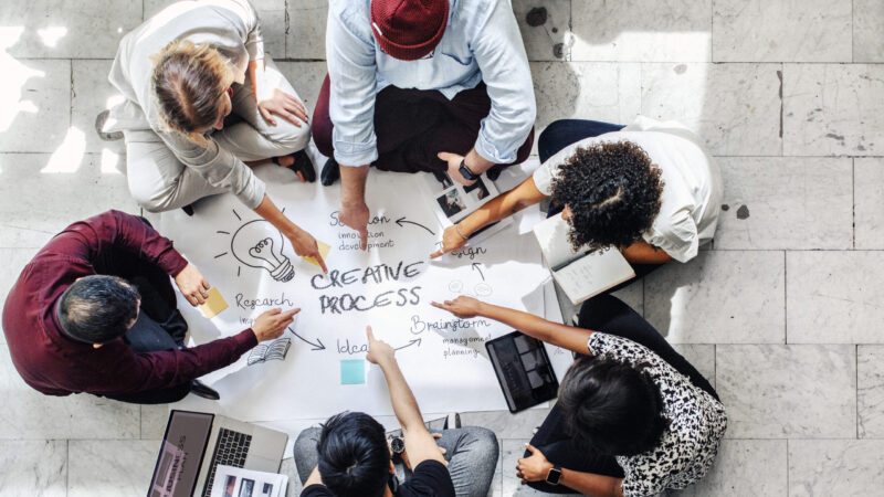 Business people brainstorming management process on paper